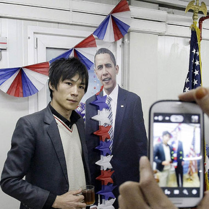 An Afghan youth poses next to the cardboard cutout of President Barack Obama for a cell phone snapshot during a U.S. presidential election event at the U.S. embassy in Kabul, Afghanistan.