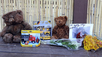 Toys and flowers are left at the entrance to the overlook of the African painted dog exhibit at the Pittsburgh Zoo and PPG Aquarium. The exhibit is now closed after the death of a 2-year-old boy on Sunday.