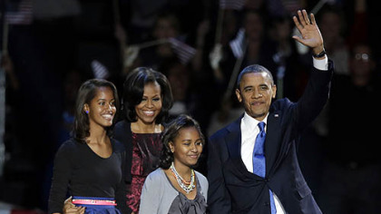 President Barack Obama waves as he walks on stage with first lady Michelle Obama and daughters Malia and Sasha at his election night party in Chicago.
