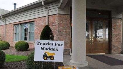 A dump truck is left at the entrance of the Slater Funeral Home in Scott on Thursday in honor of Maddox Derkosh.