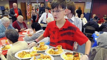 Andrew Lesnett, a seventh-grader at Shaler Area Middle School, carries a tray of food for awaiting veterans during the school district's Celebration of Veterans breakfast Wednesday at the middle school.