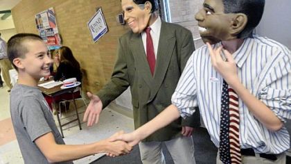 Eighth-grader Sean Beal, 13, as President Barack Obama, greets fellow student Daniel Stanton, 13, left, while eighth-grader Nicholas Palley, 13, as Mitt Romney, waits for his turn during a mock presidential election at North Hill Junior High School in Ross last Thursday. The election, organized by eighth-grade social studies teacher Joe Welch, saw 720 students register to vote. Mr. Romney won by 11 votes at the school, but Mr. Obama prevailed in districtwide returns.