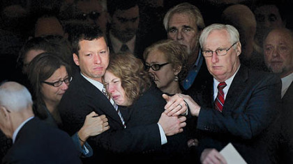 Jason and Elizabeth Derkosh, the parents of Maddox Derkosh, the 2-year-old who died after falling into the African painted dog exhibit at the Pittsburgh Zoo, watch as pallbearers carry their son's casket out of St. Bernard Church in Mt. Lebanon after the boy's funeral today.