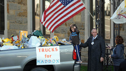 A boy looks into a truck full of donated toy trucks outside the funeral for Maddox Derkosh, the 2-year-old who died after falling into the African painted dog exhibit at the Pittsburgh Zoo, at St. Bernard Church in Mt. Lebanon.