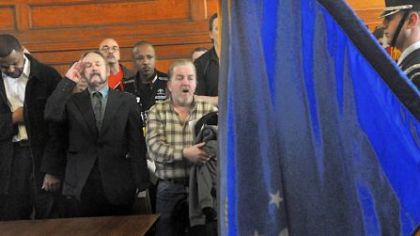 After the presentation of the colors during the Veterans Court graduation ceremony, graduates, from left, Casey Ashley, James Afanesko and Allan Adams react to the singing of the national anthem Thursday at the Allegheny County Courthouse.