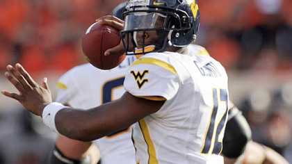 West Virginia quarterback Geno Smith looks for an open receiver during the first half.