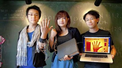 H2L Inc. CTO/director Ken Iwasaki, left, CTO/CEO Emi Tamaki, center, and adviser Masaaki Sugimoto display the PossessedHand at the Lab-Cafe in Tokyo. H2L, maker of the hand, uses a system for controlling a user's hand gestures by applying electrical simulation to the user's forearm muscles.