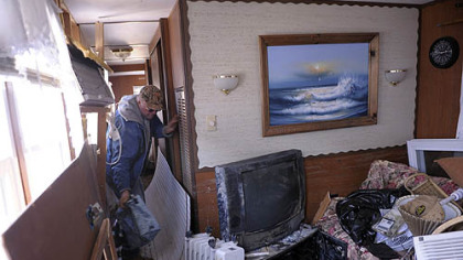 Roger Hacker, of Doylestown, Pa., on Friday finds the lunch cooler his wife liked among the debris in his mobile home in Holgate, Long Beach Island, N.J., where they had vacationed for many years.