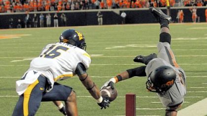 Oklahoma State receiver Josh Stewart, right, dives in for one of his three touchdowns Saturday against West Virginia. Stewart caught 13 passes for 172 yards and also rushed for 46.