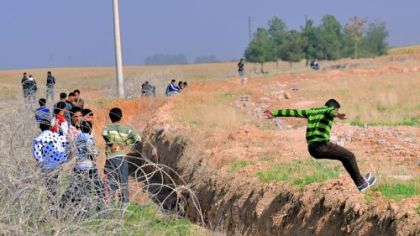 Syrian nationals cross the border between the Syrian town of Ras al-Ain and Turkey's Sanliurfa province town of Ceylanpinar.
