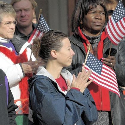 Spectators listen to the national anthem during Saturday's Veterans Day Parade, Downtown. One of the largest Veterans Day parades in the nation, this year's was dedicated to post-9/11 war veterans and their families.