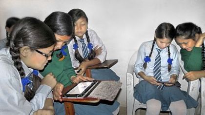 Girls sponsored by the Rukmini Foundation explore e-readers donated for their use.