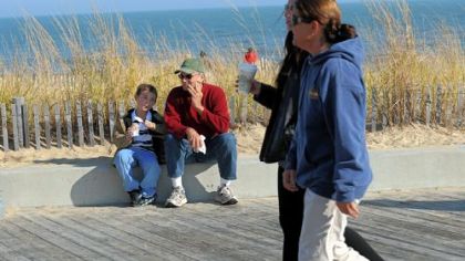 Tommy Czachorowski, 6, of Clayton, Del., sits Sunday with his grandfather, Jim Dearie, to eat sherbet along the boardwalk in Rehoboth Beach, Del.