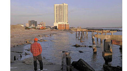 Randy Rocha of Cherry Hill, N.J., surveys a section of boardwalk destroyed by Superstorm Sandy in northern Atlantic City. The boardwalk in front of the resort city?s casinos remains intact.
