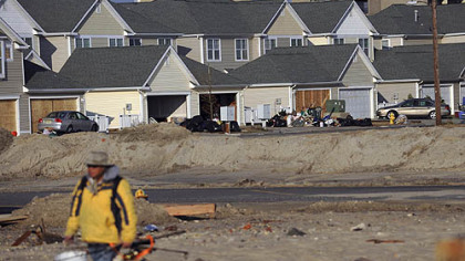 Repairs have begun on North St. Katherine's Place, one block from the ocean, in Atlantic City, N.J. Ray Guangon of Cherry Hill, N.J., walks through debris and sand to go fishing. He normally fishes on Barnegat Island, but it is closed after the storm.