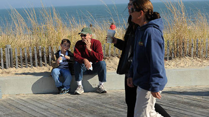 Tommy Czachorowski, 6, of Clayton, Del., eats orange sherbet Sunday with his grandfather Jim Dearie of Rehoboth Beach, Del., along the boardwalk in Rehobeth Beach.