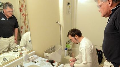 Albert Astala of Miracle Method installs a commode last week at a senior citizens apartment in the Union Aid buildings in Sewickley as John Savage, owner of Miracle Method, looks on.