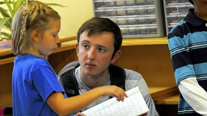 Olivia Vybiral, a second-grader at Glen Montesori School in Ross, descibes her lessons to Duquesne University freshman Mack Barr.