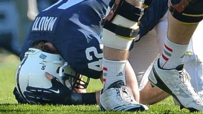 Penn State linebacker Michael Mauti grimaces, clutching his helmet, after injuring his left knee in the first half.