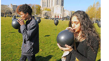 Darmante Gomez, left, a student at Community College of Allegheny County, and Laila Al-Soulaiman, a student at The Ellis School, blow up some of the 300 black balloons that students placed on plastic garden stakes in Schenley Plaza in Oakland on Thursday. Each of the 300 stakes represented 100 people who have died in Syria since March 2011. Students handed out fliers that compared the death toll of 30,000 Syrians to the population of Monroeville.
