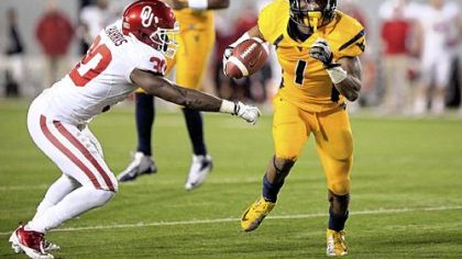 West Virginia wide receiver Tavon Austin (1) slips past Oklahoma's Javon Harris (30) for a rushing touchdown Saturday in Morgantown, W.Va.