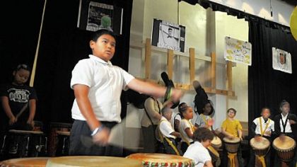 Fourth-grader Roberto Morris plays his drums at the start of the morning assembly at Pittsburgh Dilworth in East Liberty.