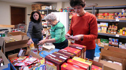 From left, volunteers Karen Corral, Beverly Aufman and Barb Gesmond sort food donations at the North Hills Community Outreach for the annual Thanksgiving food distribution.