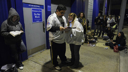Jeremy Martin and his wife Jennifer Martin of Baltimore, Md., look through ads as they wait in line outside Toys R Us in Robinson.