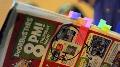 Brenda Sturgeon of McDonald holds her marked and tabbed advertisement insert as she waits in line outside Toys R Us in Robinson before the 8 p.m. opening of the store on Thursday.