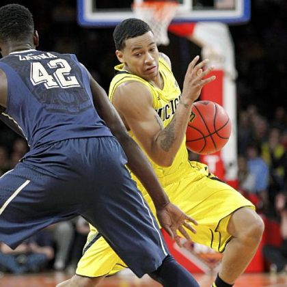 Michigan's Trey Burke, right, attempts to drive around Pitt's Talib Zanna in the semifinals of the NIT Season Tip-Off Wednesday night at Madison Square Garden.
