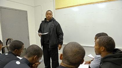 Defensive coach Wayne Wade, 40, goes over strategy with the Bears in the team's weight room in November. Wade, who is from Clairton, was the team's quarterback in 1989 when the Bears won the WPIAL Class A championship.
