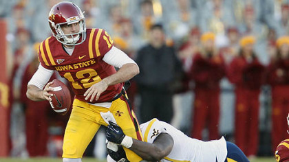 Iowa State quarterback Sam Richardson, left, scrambles as he is pulled down by West Virginia defensive lineman Shaq Rowell, right, during the first half of an NCAA college football game Friday, in Ames, Iowa.