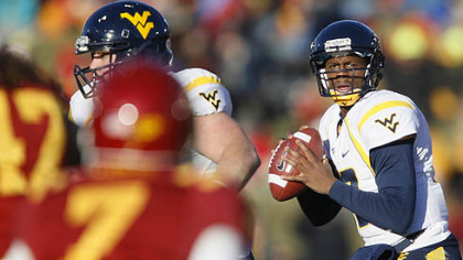 West Virginia quarterback Geno Smith, right, drops back to pass during the first half of an NCAA college football game against Iowa State, Friday, in Ames, Iowa.