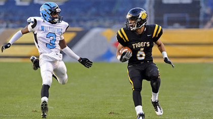 North Allegheny's Elijah Zeise carries as as he's defended by Woodland Hills' Trevon Mathis Friday in the WPIAL class AAAA championships at Heinz Field.