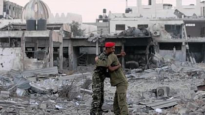 Hamas police officers embrace after their return to their destroyed Al-Saraya headquarters in Gaza City on Thursday.