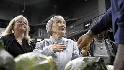 Mary Jane Ehrler, 89, of Brighton Heights, center, greets the Steelers' Maurkice Pouncey during a Thanksgiving turkey give-away Wednesday, presented by the Max Starks Hometown Team and the Greater Pittsburgh Community Food Bank at Stage AE on the North Shore. Patty Van Dillen, left, is the special events coordinator for the food bank.