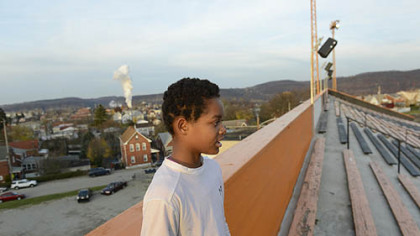 Sixth-grader Corey Johnson, 12, came early for his Mighty Mites football practice so he could watch the Clairton Bears practice. "Someday I'll be on the team," he says.