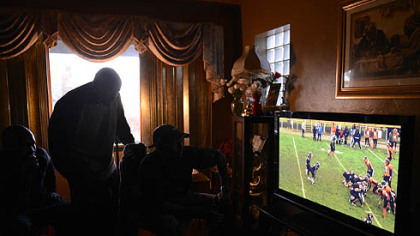 Midget football coaches, from left, Quintin Brody, Dennis Dreher and Corey Wright review film at Wright's house in October.