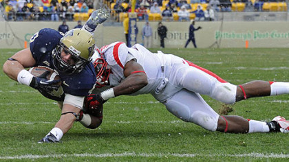 Pitt's Mark Giubilato dives for yardage as he's defended by Rutgers' Jamal Merrell in the second quarter this afternoon at Heinz Field.