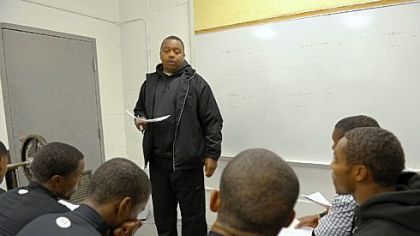 Defensive coach Wayne Wade, 40, goes over strategy with the Bears in the team's weight room in November. Wade, who is from Clairton, was the team's quarterback in 1989 when the Bears won the WPIAL Class A championship.