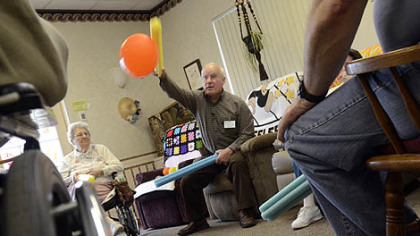 Alan Romatowski takes part in an exercise with other patients at Concordia Adult Day Services, using foam sticks to bat away balloons.