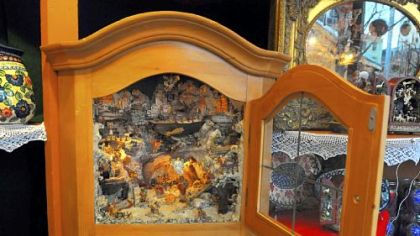 Among items at the Alpine Heritage booth are handcrafted Austrian Nativity scenes that open like a chest. Above is a corner hutch with a glass-plated door that sells for $1,900.