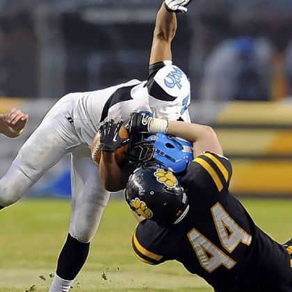 Woodland Hills' Dequan White is pulled down by North Allegheny's Kevin Edwards during WPIAL championship game at Heinz Field.