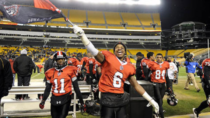Aliquippa's Dravon Henry waves his school's flag after defeating Washington Friday in the WPIAL class AA championships at Heinz Field.