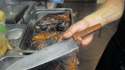 John Heidelmeier displays a knife he created for a chef in the kitchen of Bar Marco in the Strip District.