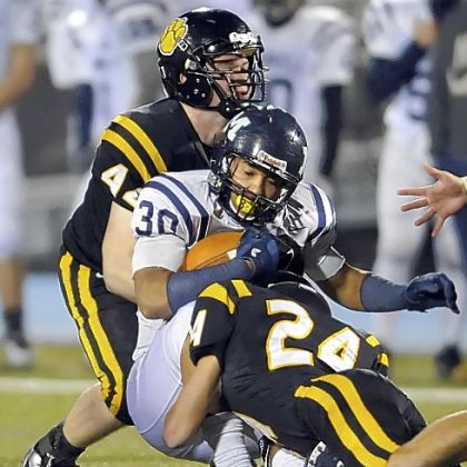 North Allegheny's Kevin Edwards and Ben Schweiger take down McDowell's James Conner Friday night.