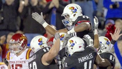 Kansas running back James Sims (29) celebrates with teammates after a big play as Iowa State defensive lineman Ben Durbin (15) walks off the field during the first half in Lawrence, Kan., Saturday, Nov. 17, 2012.
