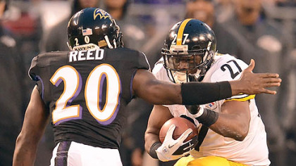 The Steelers' Jonathan Dwyer picks up yardage against the Ravens' Ed Reed in the first half.