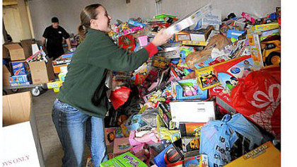Colleen Balistrieri of Brentwood works with her husband, Nino, background, to unload boxes of toys for the Marine Corps' Toys for Tots program at Guardian Storage in the Strip District.