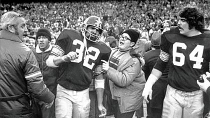Franco Harris makes his way through the chaos at Three Rivers Stadium turf in the aftermath of the Immaculate Reception.